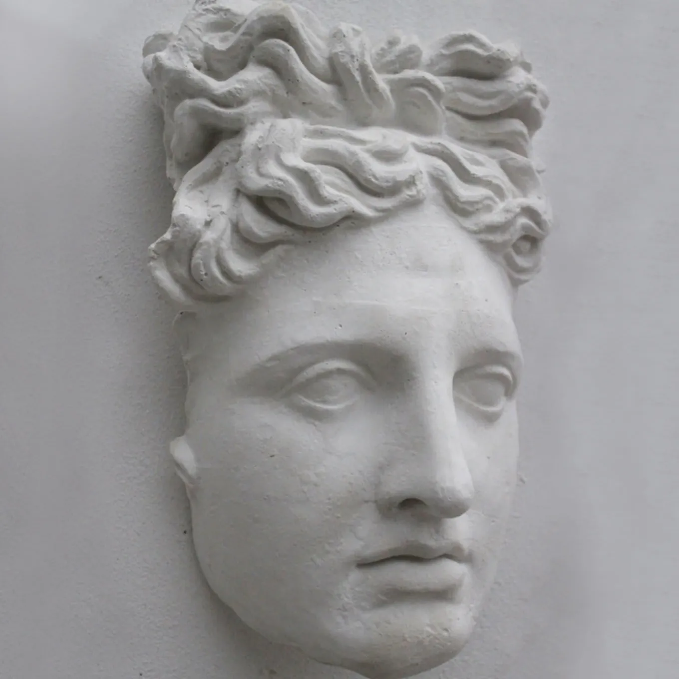 Scultura in gesso con maschera di Apollo