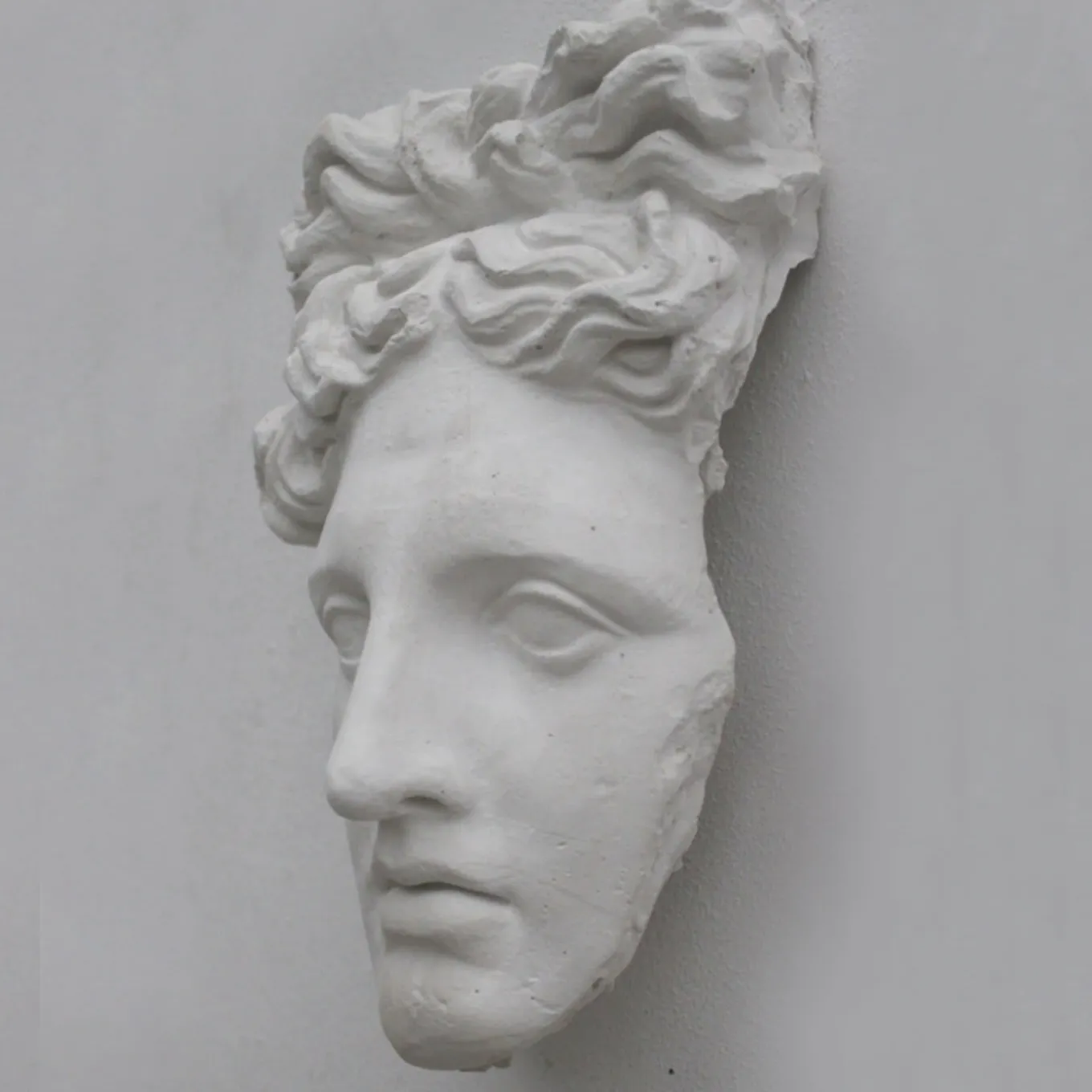 Scultura in gesso con maschera di Apollo