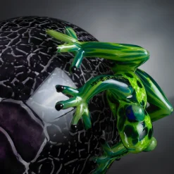 Uovo di vetro nero screziato con rane verdi